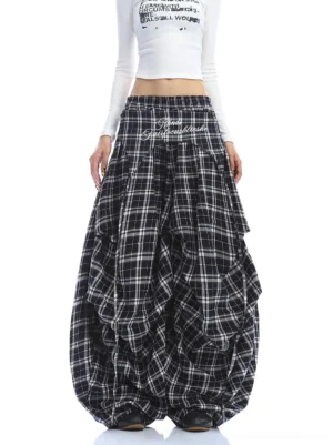 Front full-body view of black and white plaid embroidered wide-leg cargo pants styled with a cropped white long-sleeve top in a streetwear outfit