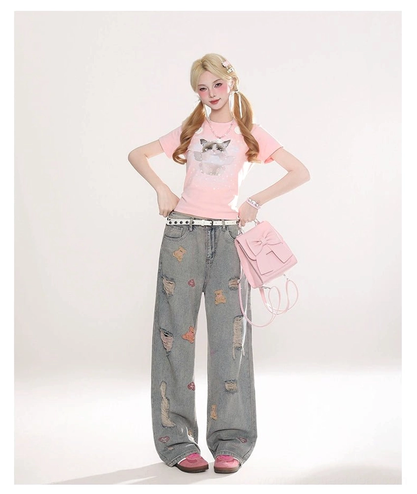 Full front styling view of embroidered teddy bear wide-leg jeans with a playful pink top and matching pink handbag