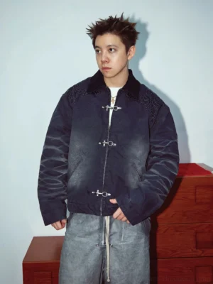 Model wearing a dark gradient embroidered toggle front utility jacket with contrast collar and relaxed streetwear styling