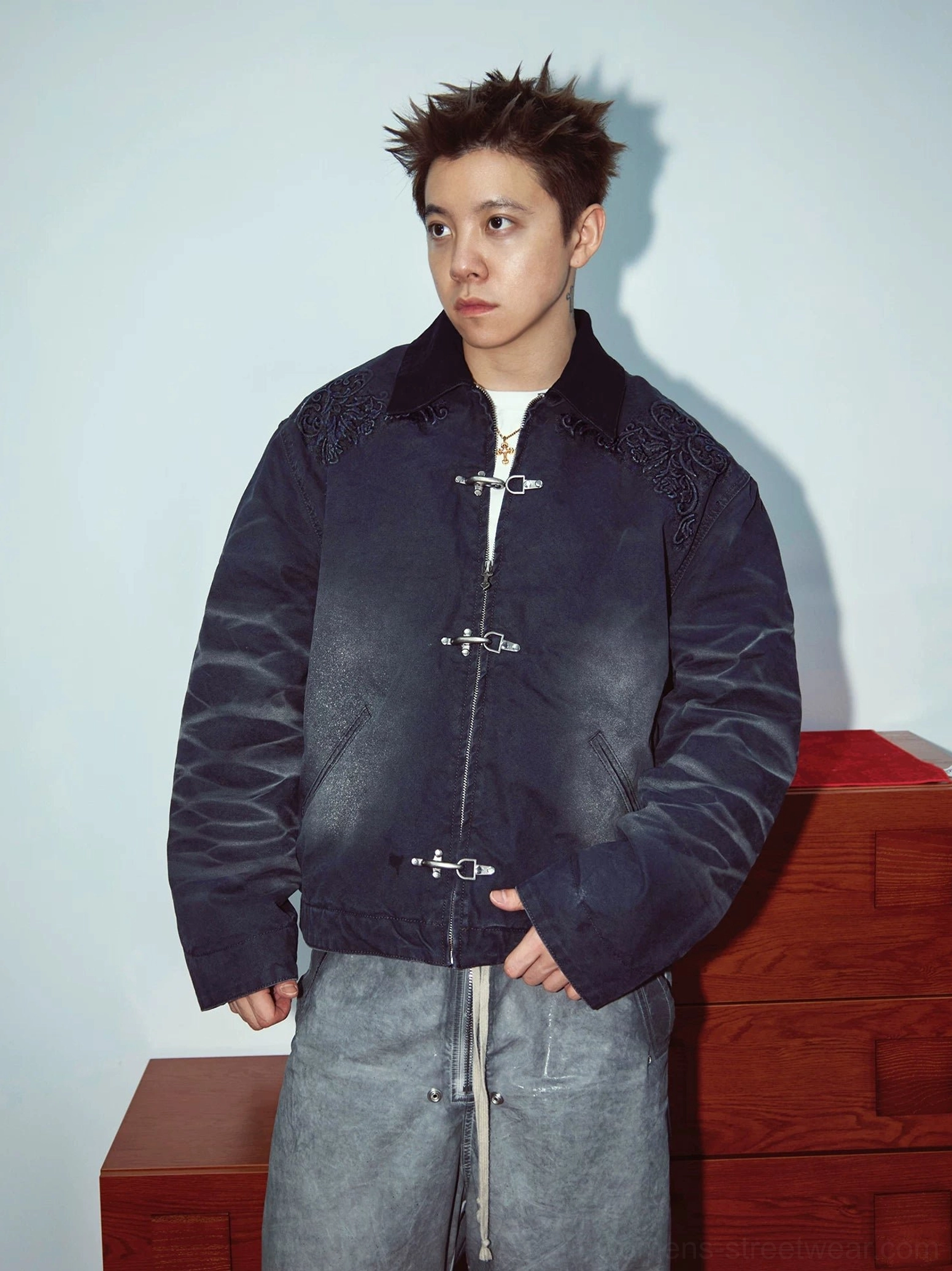 Model wearing a dark gradient embroidered toggle front utility jacket with contrast collar and relaxed streetwear styling