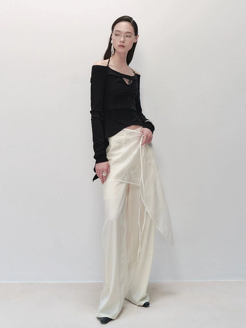Side view of embroidered sheer wrap skirt wide-leg trousers paired with a black cutout off-shoulder top