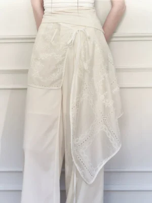 Close back waist detail of white embroidered wrap skirt wide-leg trousers showing floral sheer overlay and adjustable tie