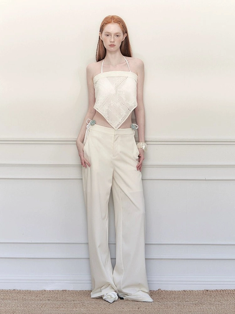 White high-waisted wide-leg trousers with a clean tailored silhouette and wrap skirt inspired streetwear styling