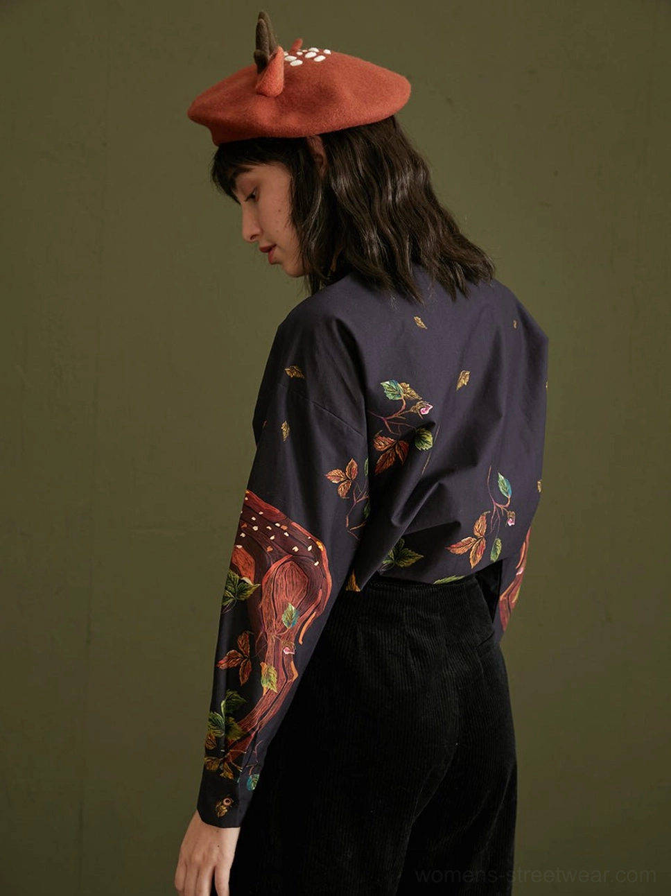 Back view of relaxed navy enchanted forest deer print cotton button-up blouse with foliage print sleeves
