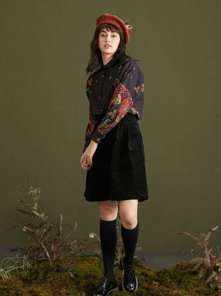 Side full-body styling view of navy deer foliage print cotton button-up blouse in woodland streetwear outfit