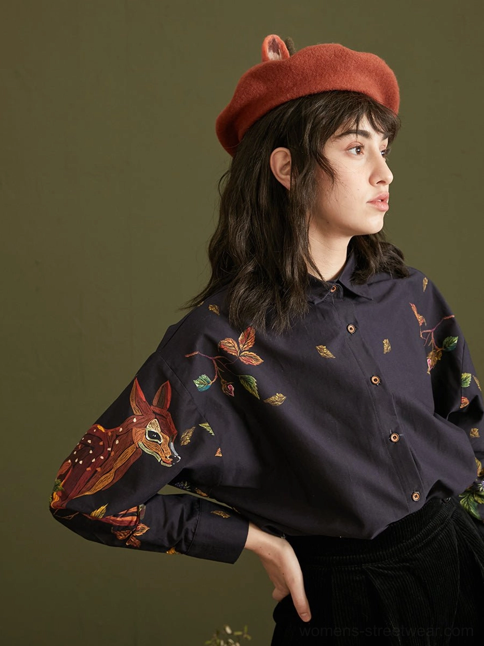 Enchanted forest deer print cotton button-up blouse in navy worn with black trousers and antler beret front view