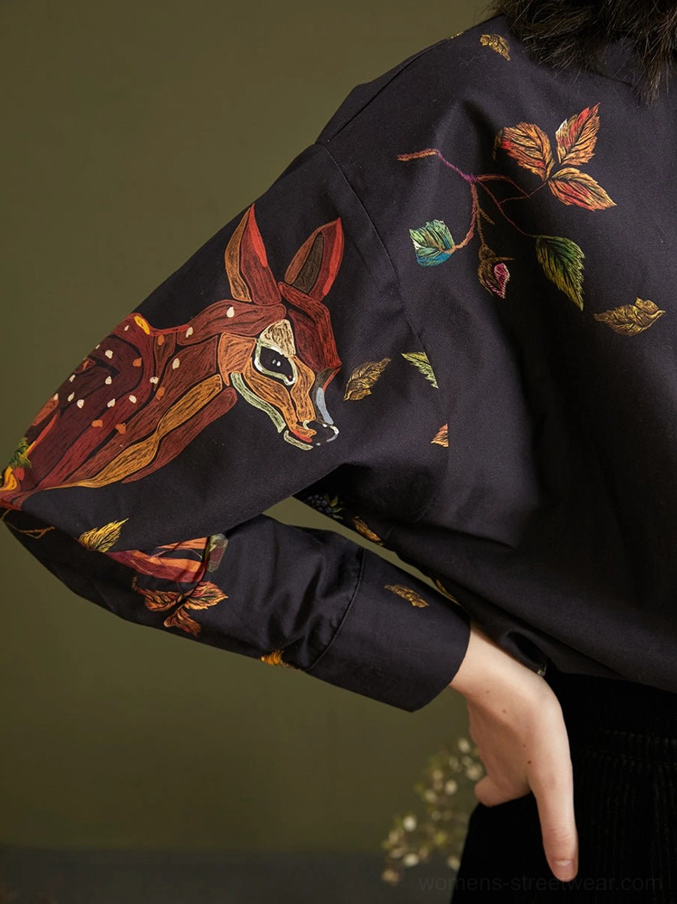Close-up of colorful fawn and botanical print on the long sleeve of enchanted forest navy cotton blouse