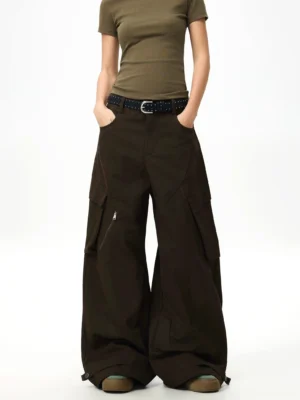 Front three-quarter view of espresso brown wide-leg streetwear cargo pants with oversized pockets adjustable ankle cuffs and olive cropped top