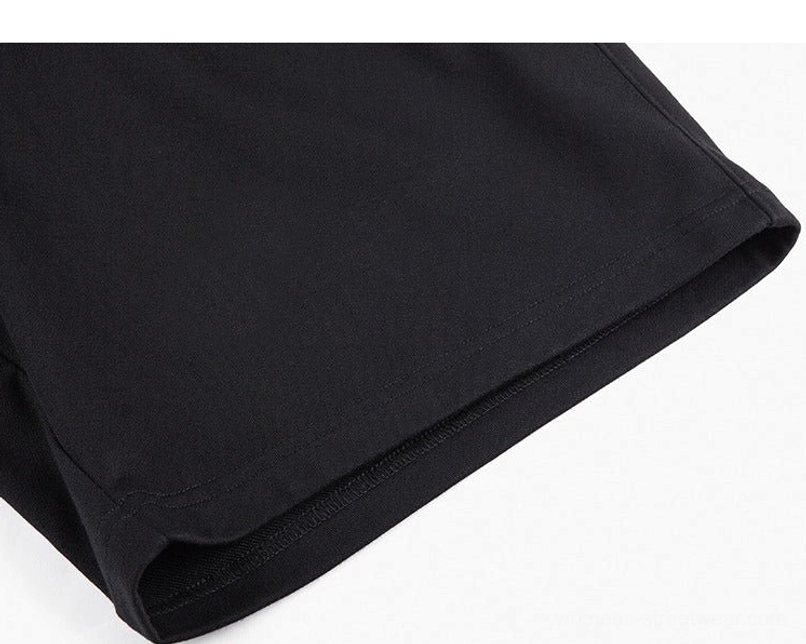 Close-up of black oversized sweat shorts hem and smooth matte cotton blend knit texture