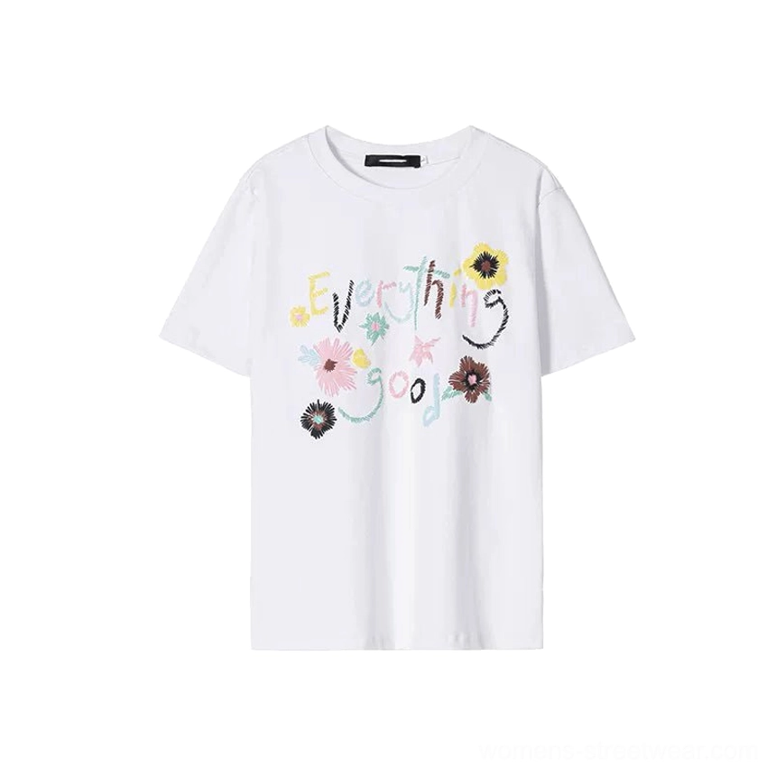 White Everything Good floral graphic cotton T-shirt displayed flat with colorful handwritten lettering and flower artwork across the chest
