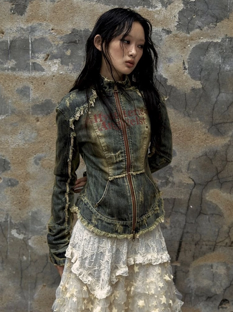 Three-quarter view of fitted distressed denim corset jacket with acid-wash finish and frayed seams