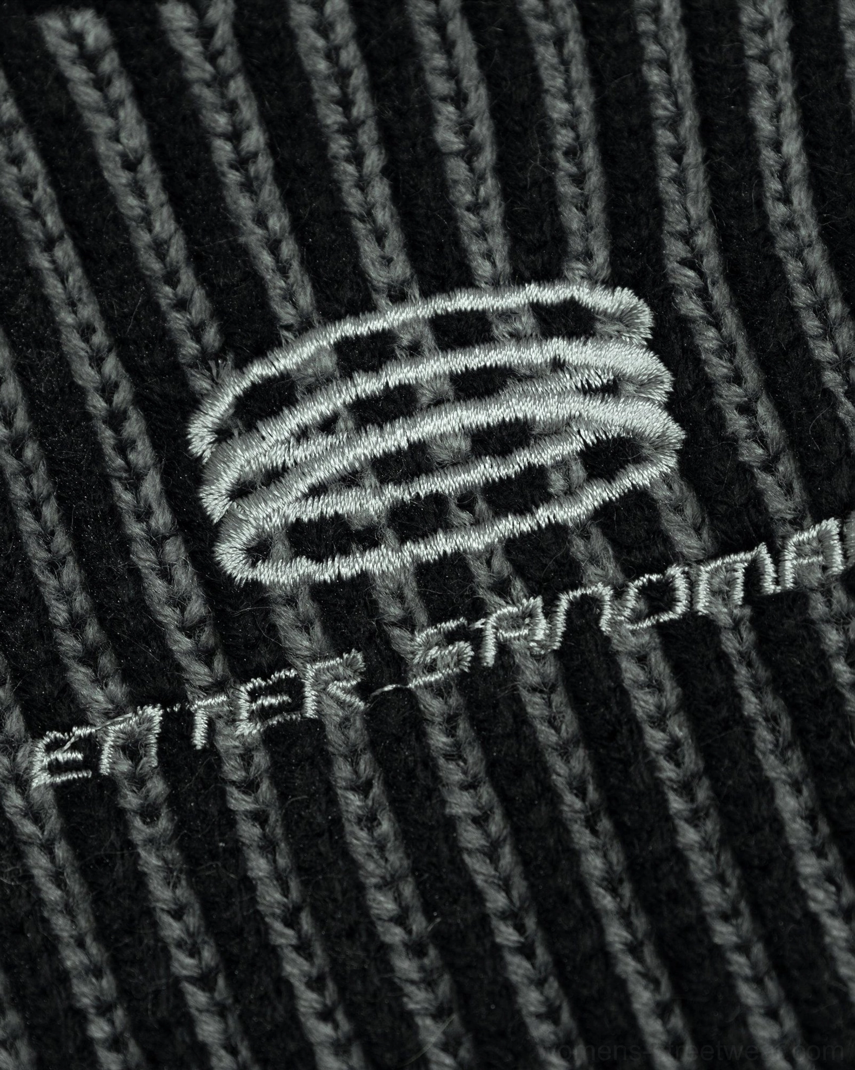 Faded black ribbed streetwear knit with subtle chest logo and deconstructed distressed accents