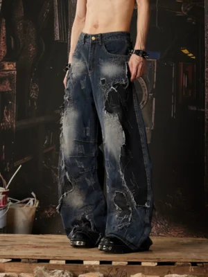 Side front view of faded blue wide-leg distressed jeans showing ripped panels, relaxed mid-rise waistband and oversized streetwear silhouette