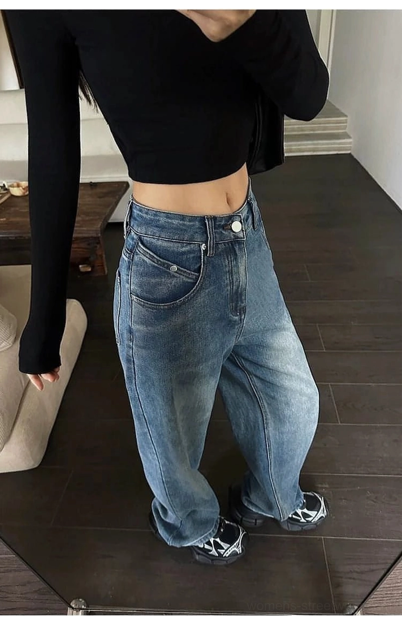 Front-side close-up of faded blue high-waist wide-leg jeans with classic pockets and relaxed streetwear fit