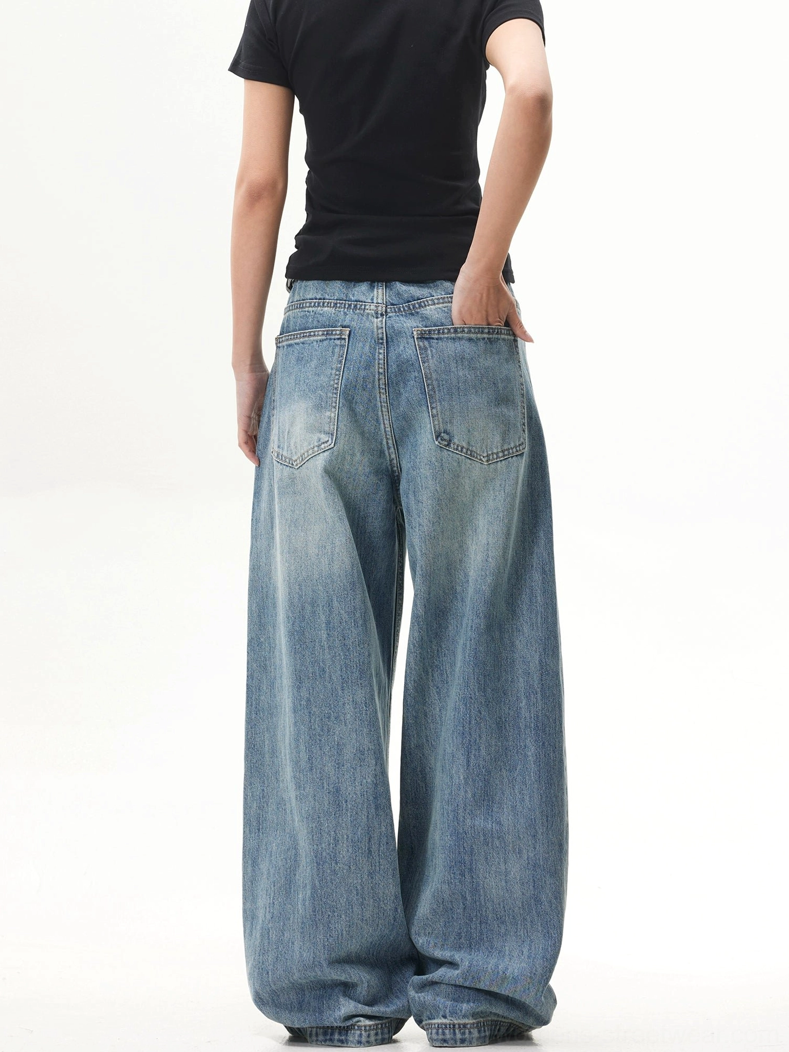 Rear side view of faded blue oversized baggy jeans highlighting the wide-leg cut and practical back pocket detail