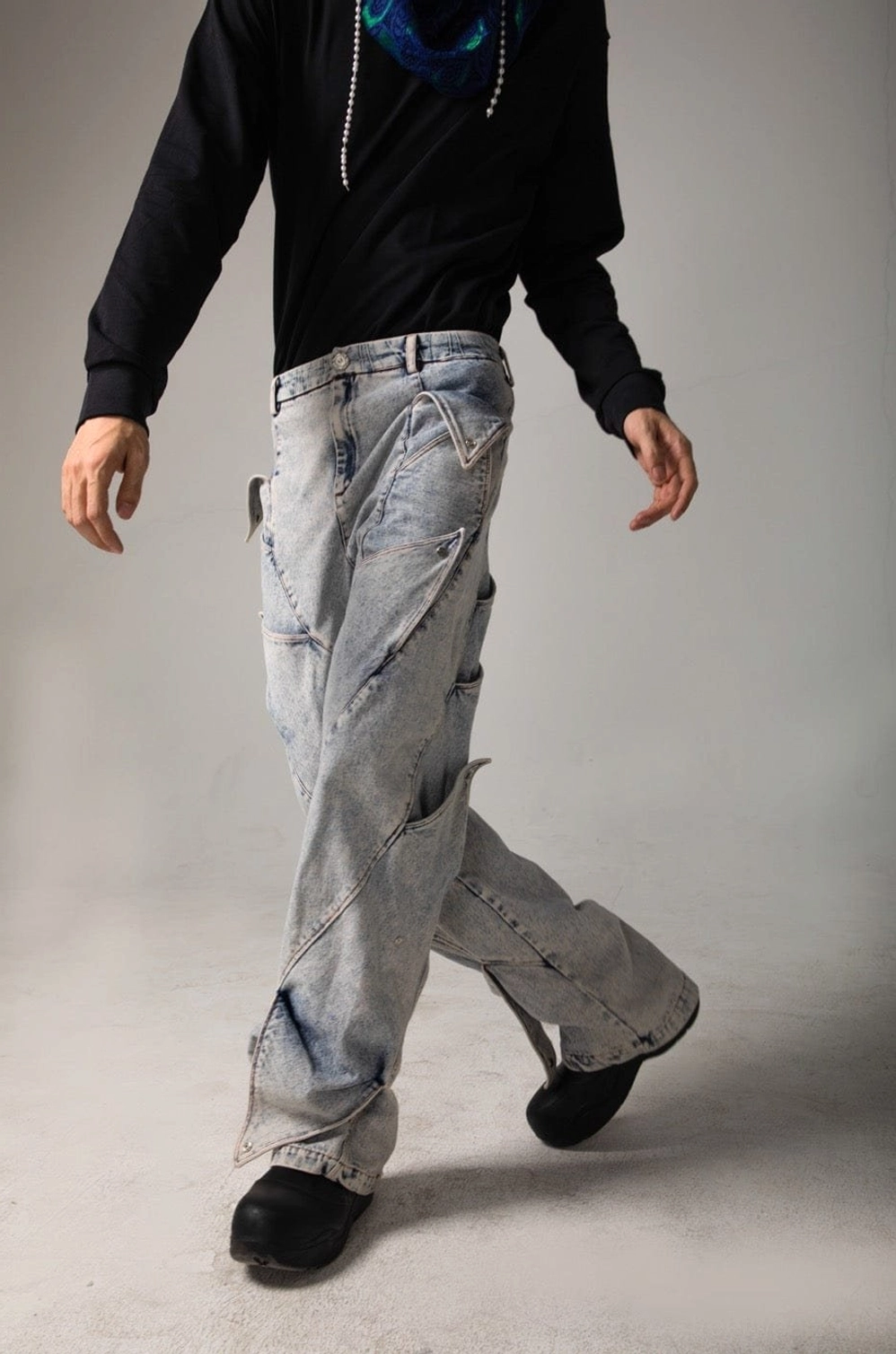 Front three quarter view of faded light blue shark fin baggy jeans with sculpted thigh panels and relaxed proportions