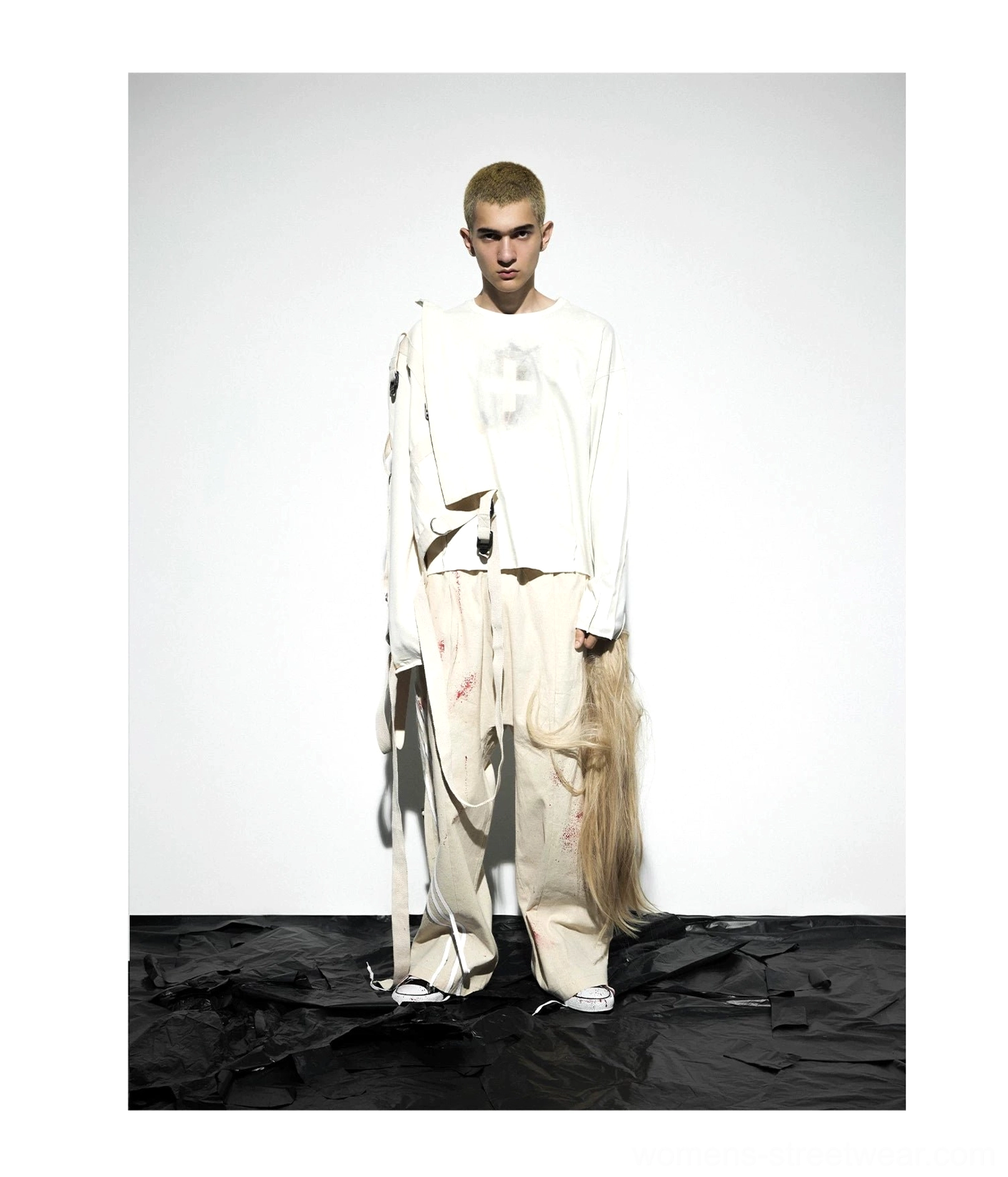 Front studio view of relaxed oatmeal gray distressed cotton long sleeve tee with faded cross print and raw-look hem