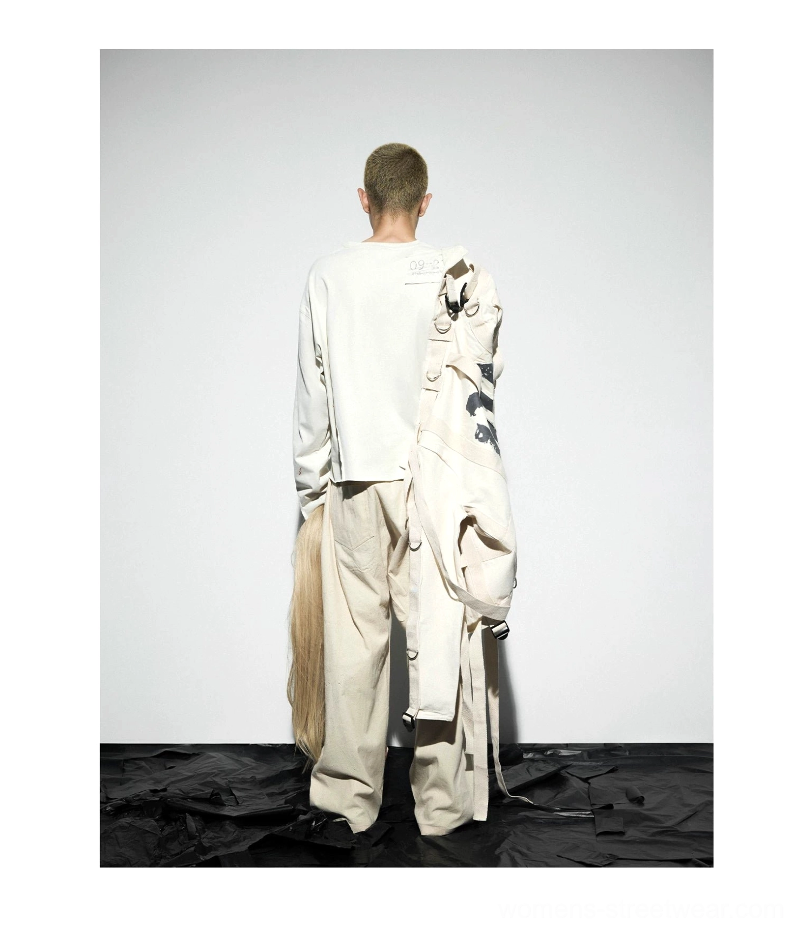 Back view of oatmeal gray long sleeve streetwear tee with subtle back shoulder patch and deconstructed styling