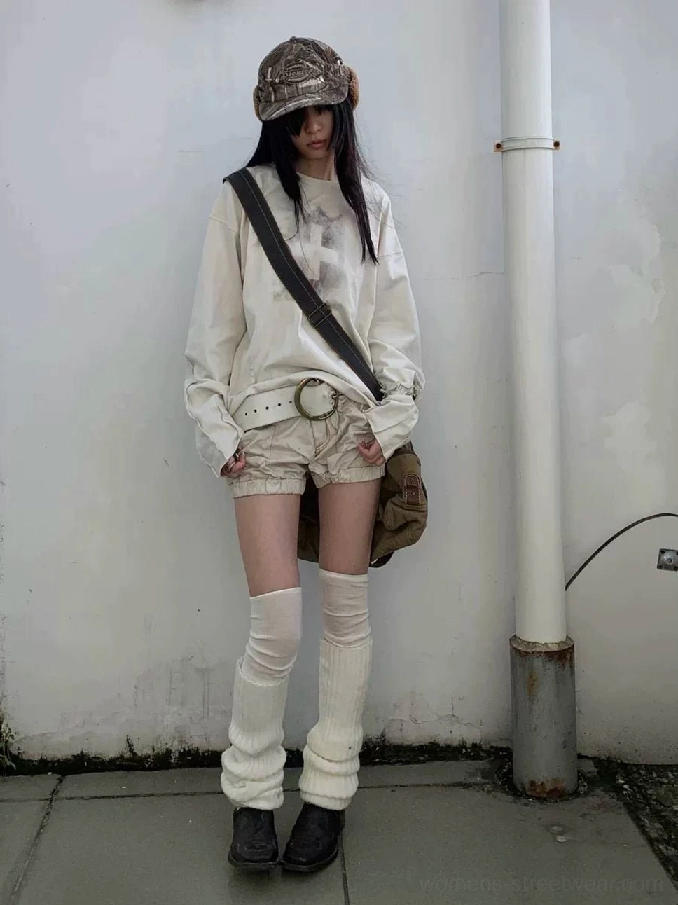 Female model front full-body view in relaxed oatmeal gray distressed cross graphic long sleeve streetwear tee