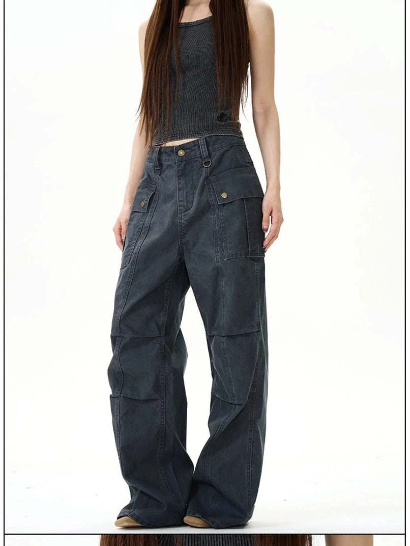Faded dark grey wide-leg streetwear cargo pants with flap pockets and relaxed silhouette styled with a crop tank top