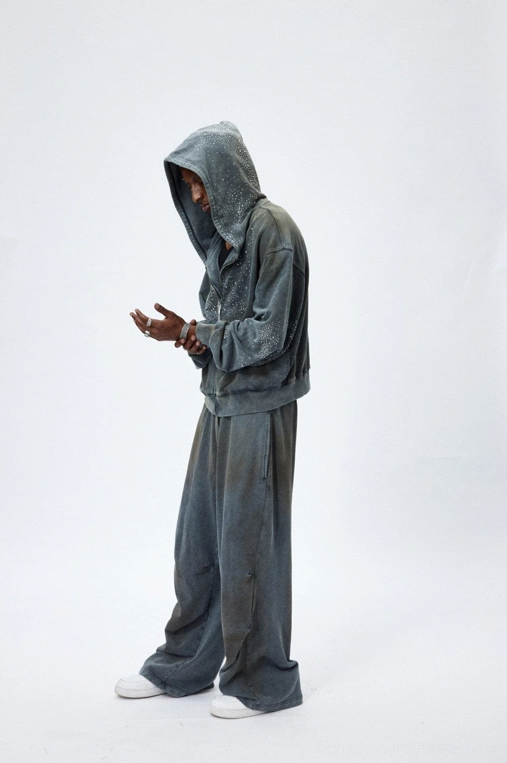 Full side view of faded grey starlight crystal zip hoodie styled with grey wide leg pants and white sneakers