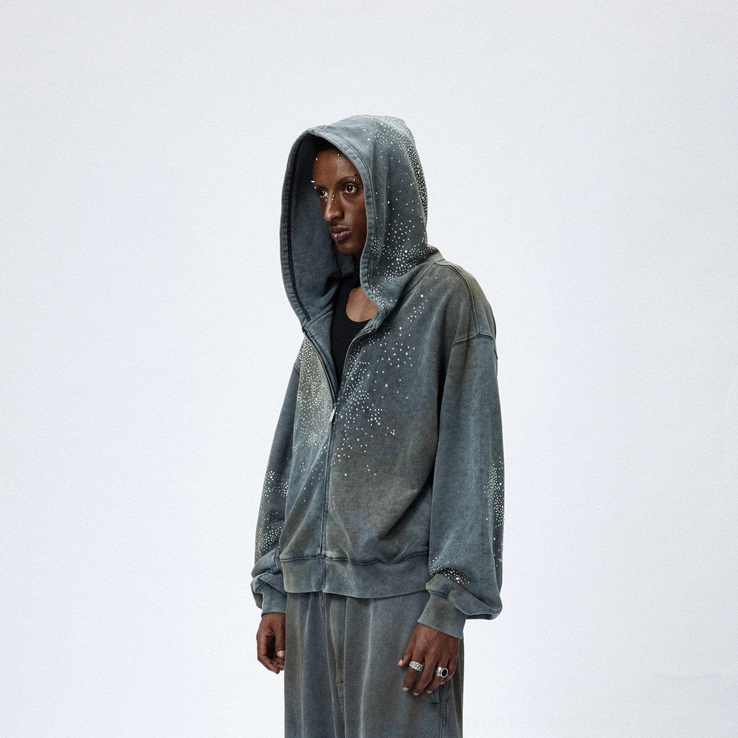 Three quarter view of faded grey starlight crystal zip hoodie with rhinestone chest detail and hood embellishments