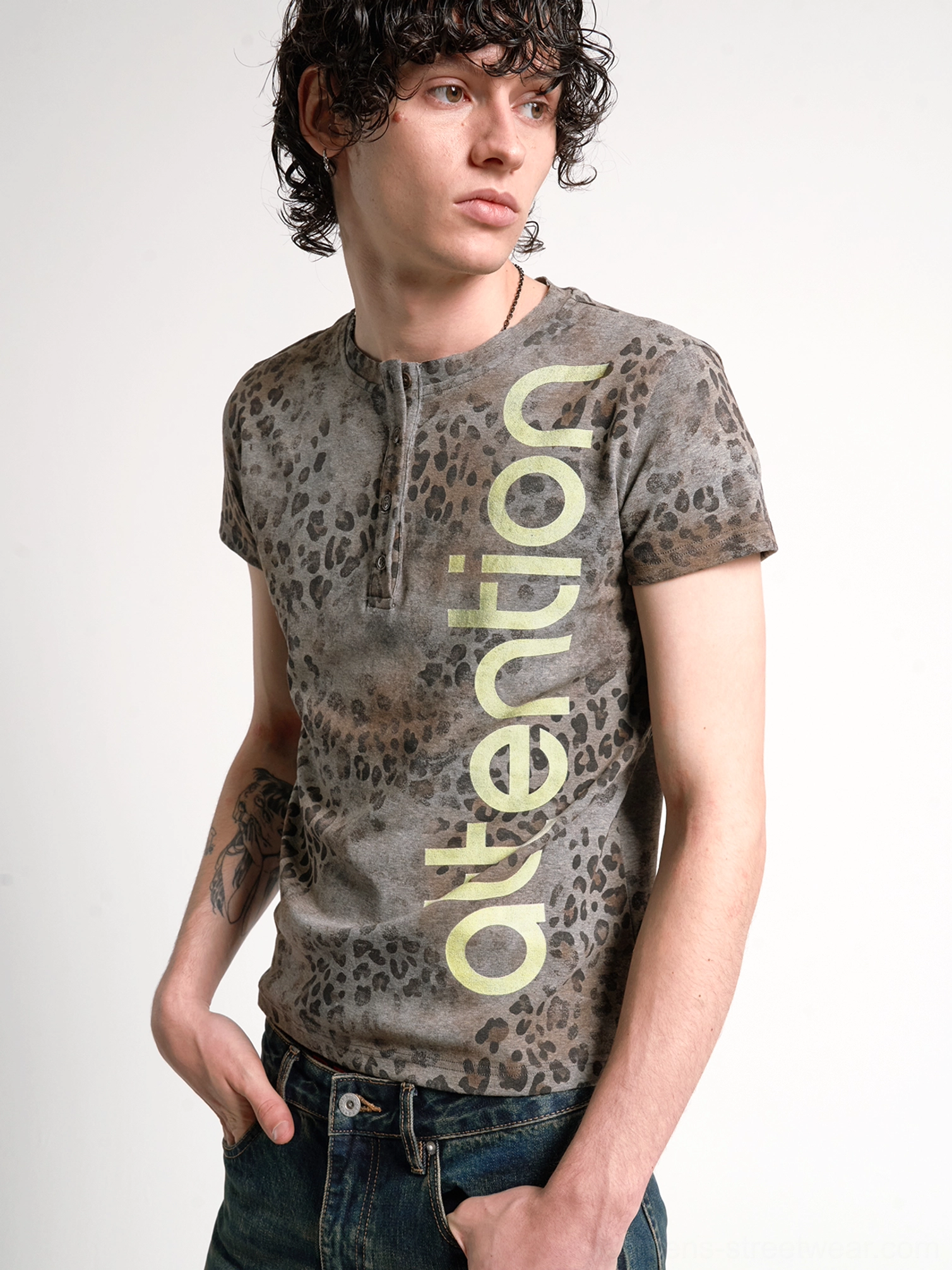 Close-up front view showing the button Henley neckline, washed leopard texture, and vertical lime attention graphic