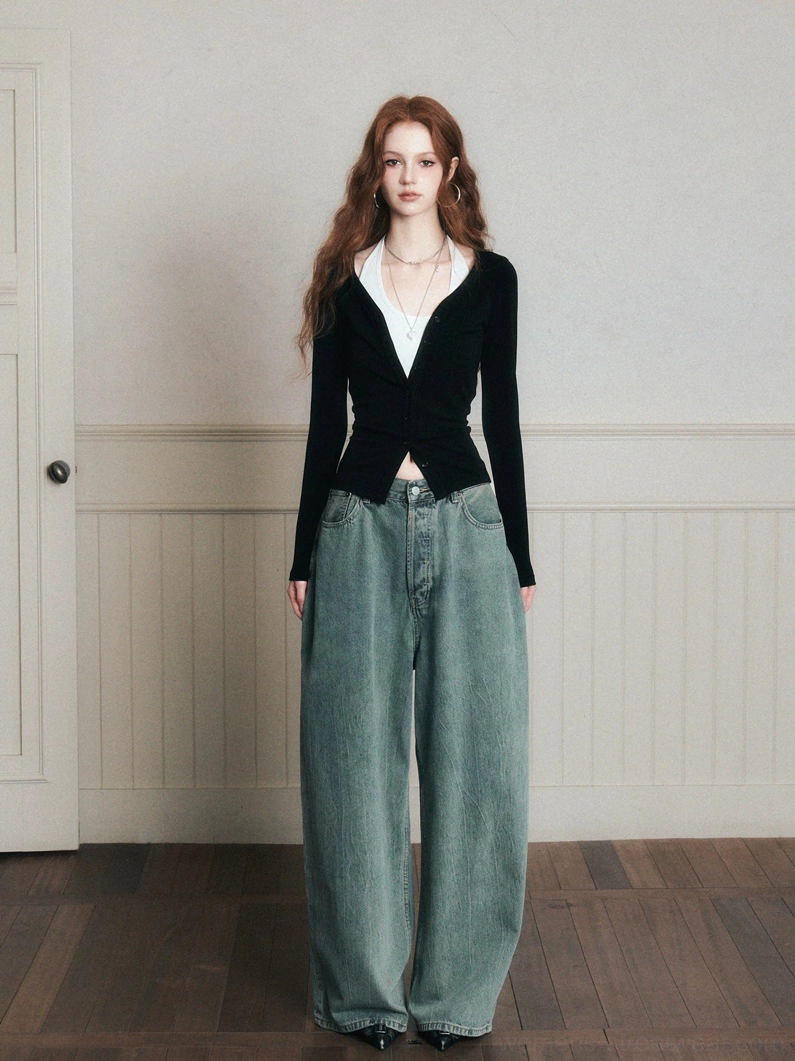 Front full-body view of women wearing faded sage blue wide-leg jeans with a black wrap-front top and classic button-fly waistband