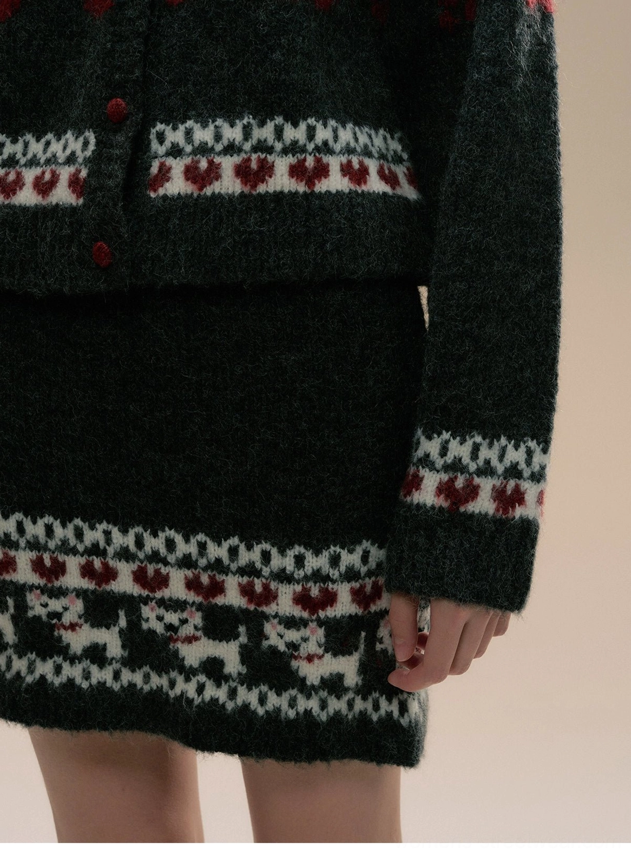 Close-up of matching Fair Isle knit skirt hem and cardigan cuffs with cat motifs and heart jacquard trim
