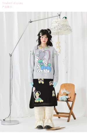Full-body view of a silver-grey cartoon knit sweater styled with a printed midi skirt and ruffled leg warmers in a playful Seoul fashion outfit