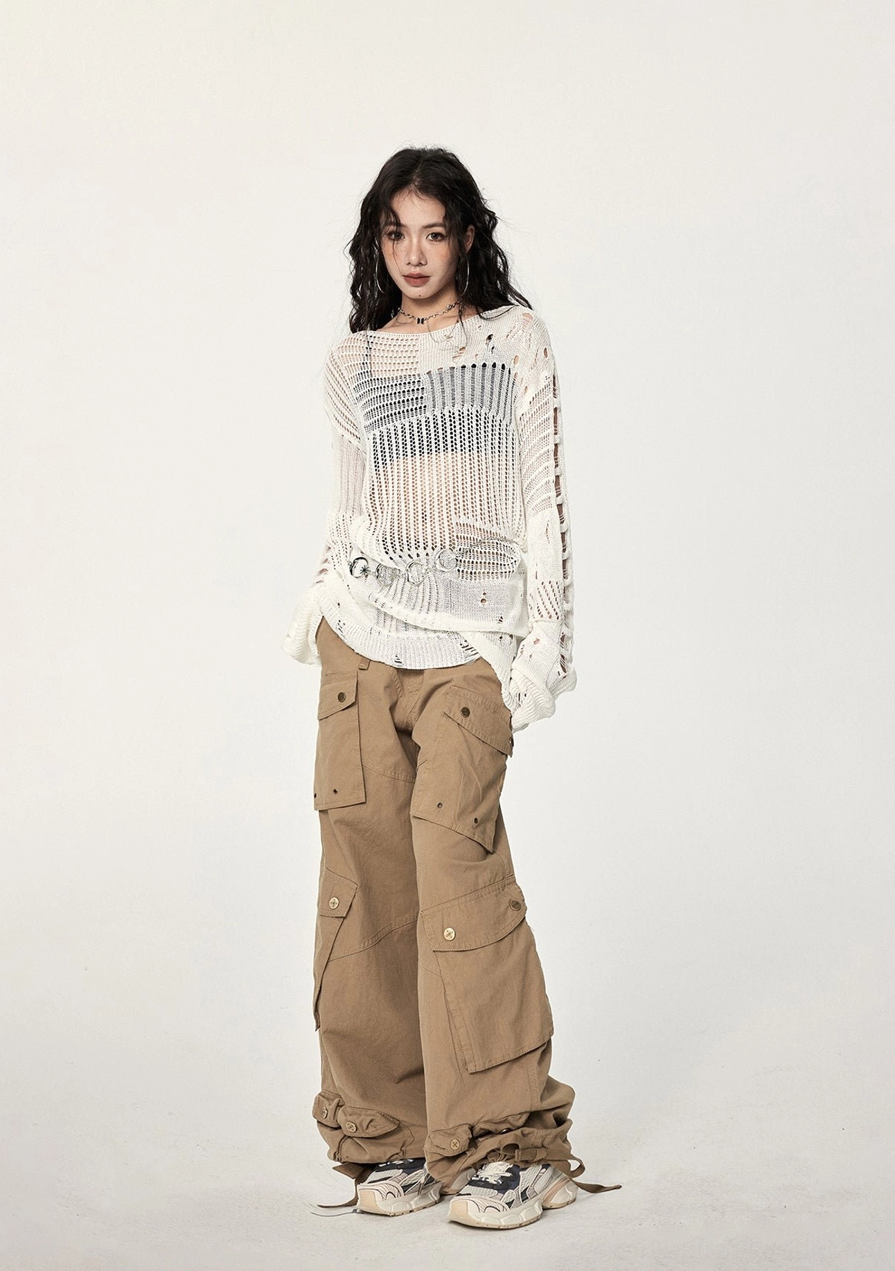 Fashion-forward distressed crochet sweater with see-through knit panels, irregular sleeve openings, metal waist details, and avant-garde styling