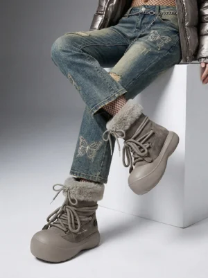 Model wearing taupe faux fur cuff platform snow boots with distressed denim and cropped puffer streetwear outfit