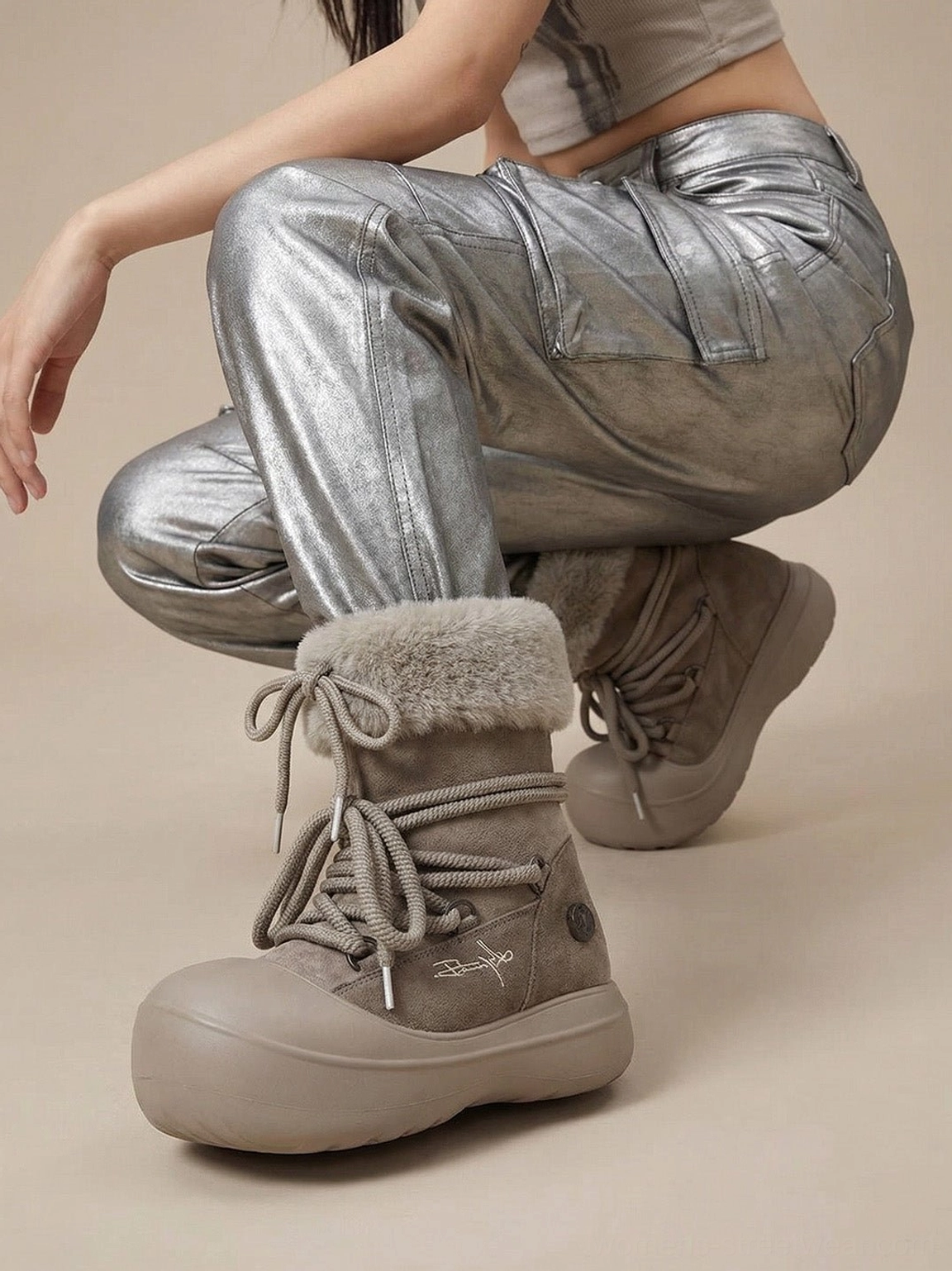 Taupe chunky platform snow boots with grey faux fur cuffs styled with metallic silver cargo pants