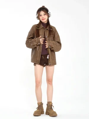 Female model wearing khaki platform combat boots with a cropped brown denim jacket dark shorts and streetwear styling