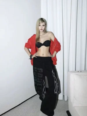 Black flame slogan graphic wide leg sweatpants styled with a red cardigan and black top in a white studio