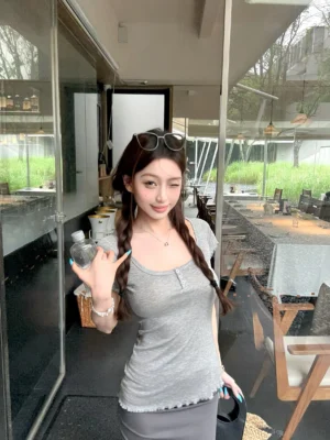 Close-up fashion view of a fitted Henley streetwear T-shirt with square neckline, front buttons, flutter sleeves, and feminine ruffled trim details