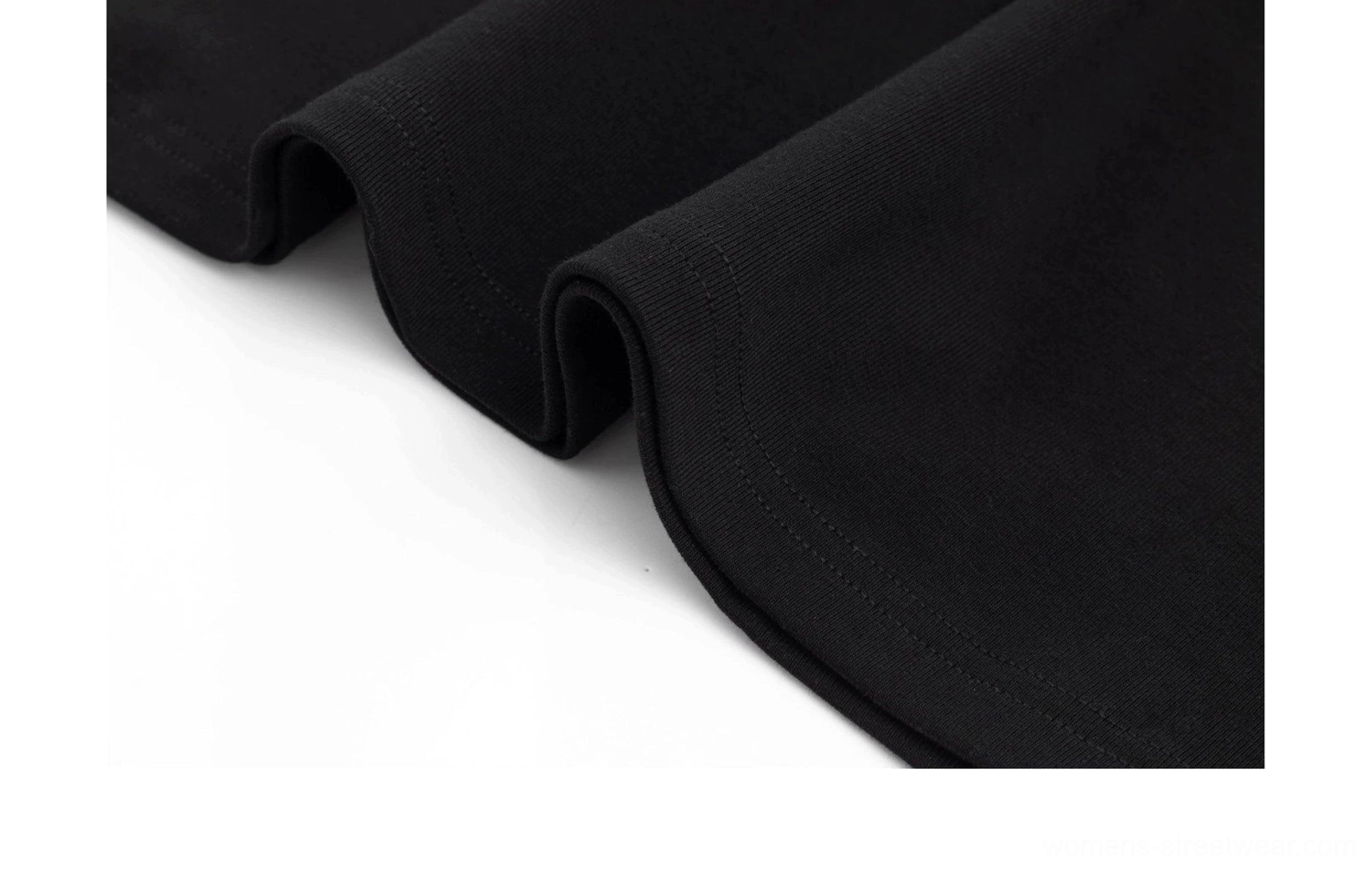 Close-up detail of the clean finished fishtail hem and softly draped knit fabric on the fitted maxi dress