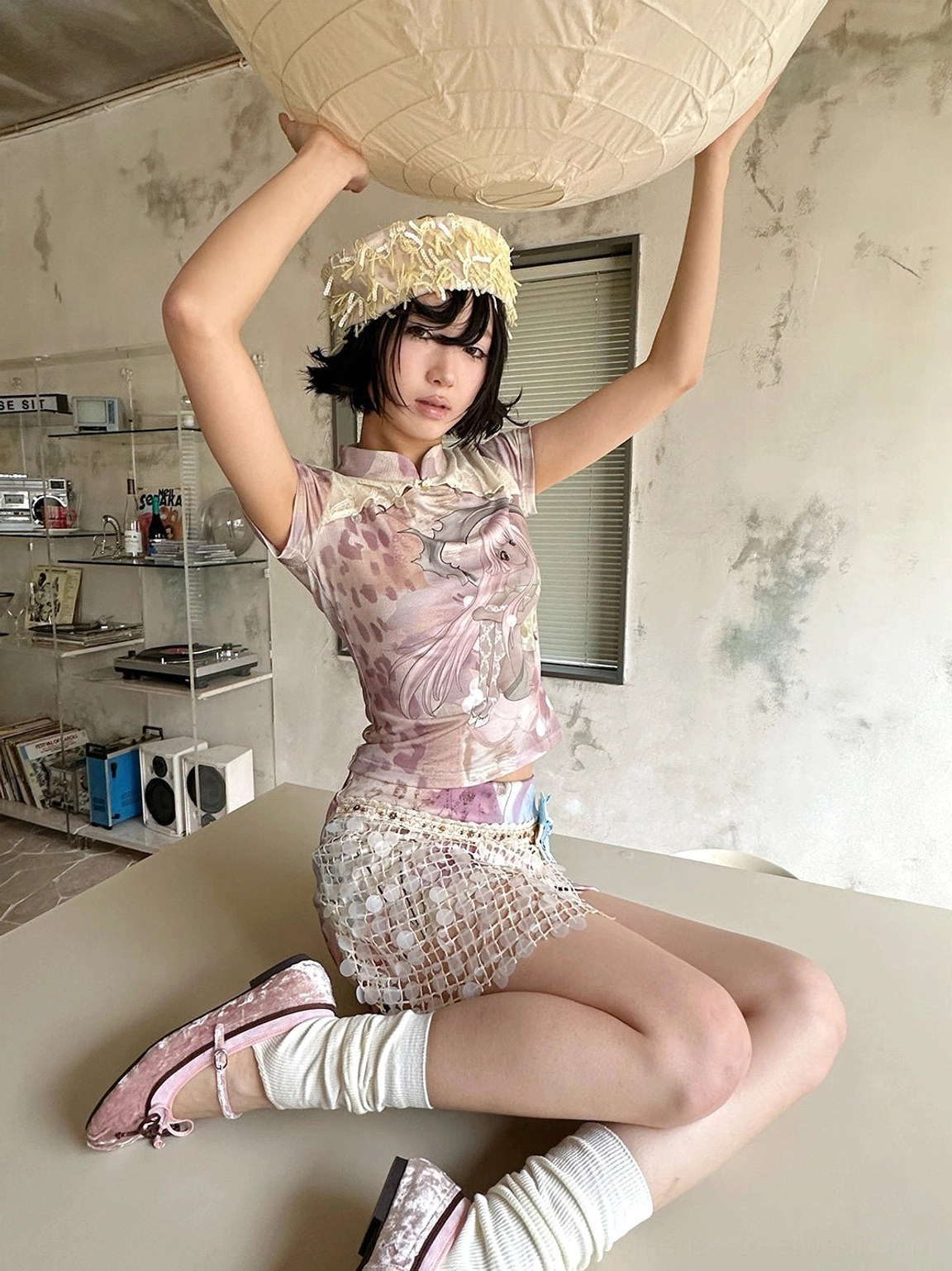 Low-angle portrait of a model wearing a fitted multicolor cheongsam collar tee with pastel anime artwork and leopard print accents