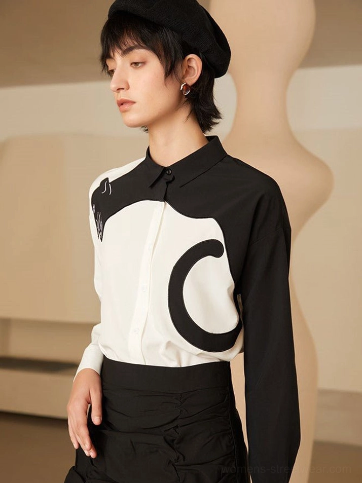 Three-quarter front view of fitted black and white panther blouse with delicate shoulder embroidery