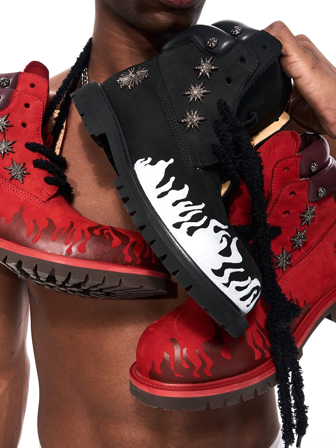 Side close-up of black and red flame appliqué genuine leather combat boots featuring flame graphics, laces, and metal accents