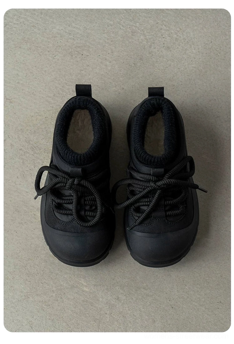 Top-down view of all-black fleece-lined platform sneakers with rounded toe, lace-up front, soft fuzzy collar, and chunky treaded rubber outsole