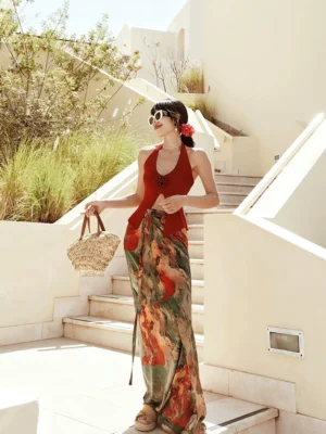 Floor-length abstract print maxi skirt with adjustable waist sash styled on villa stairs with a woven straw handbag and flower hair accessory