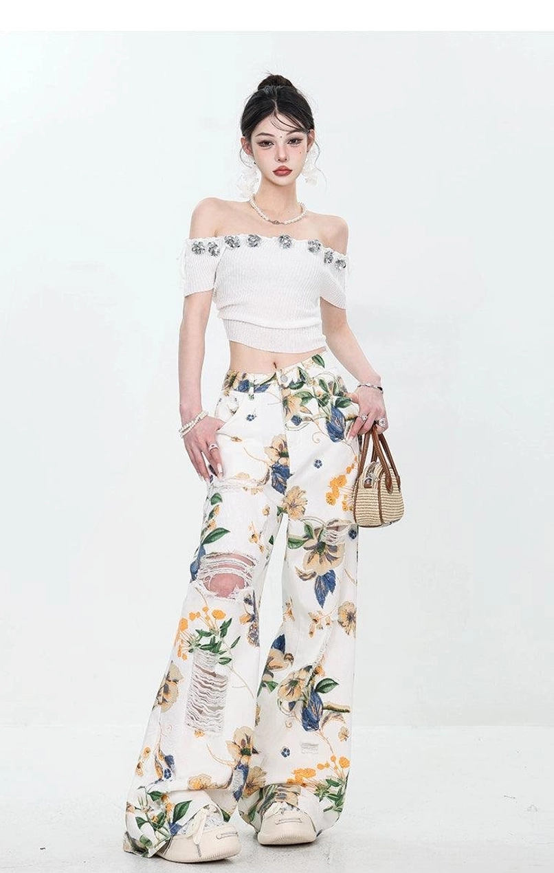 Front view of women's floral distressed wide-leg denim set styled with a woven handbag and platform sneakers