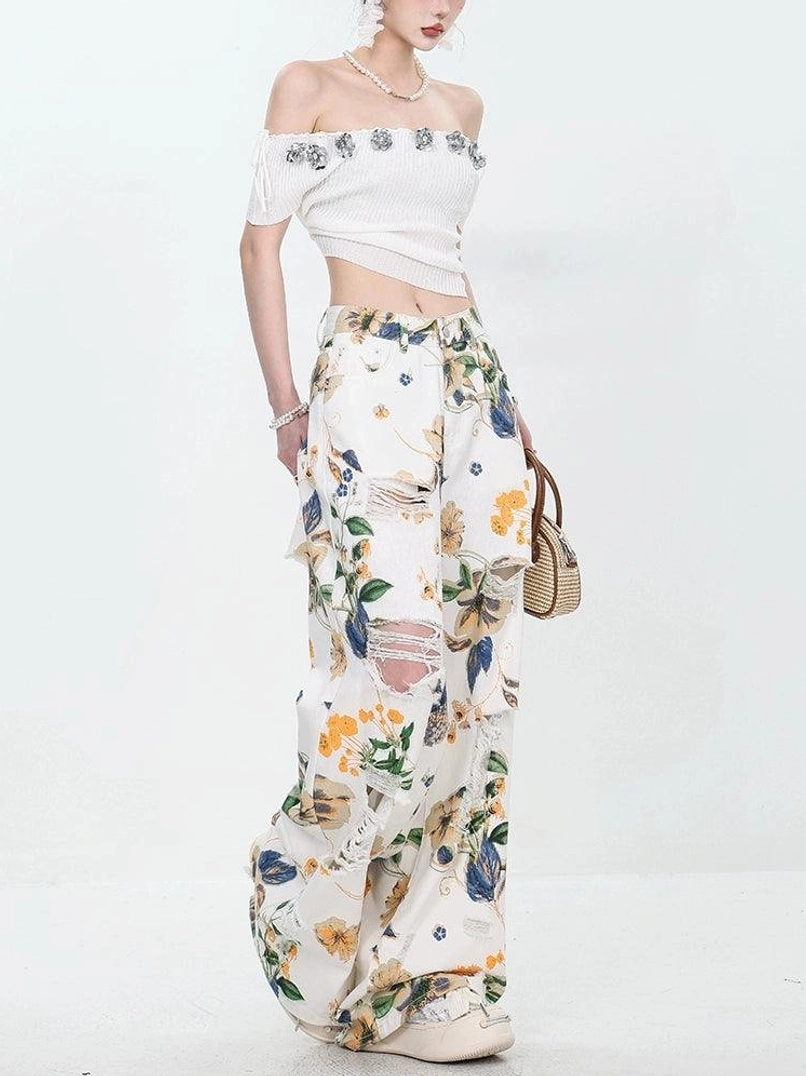 Women's floral distressed wide-leg jeans styled with an off-shoulder cropped top and platform shoes