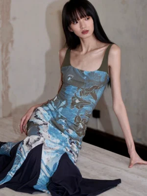 Blue watercolor floral fishtail maxi dress shown in a seated front view with contrast dark green straps and black ribbed mermaid hem