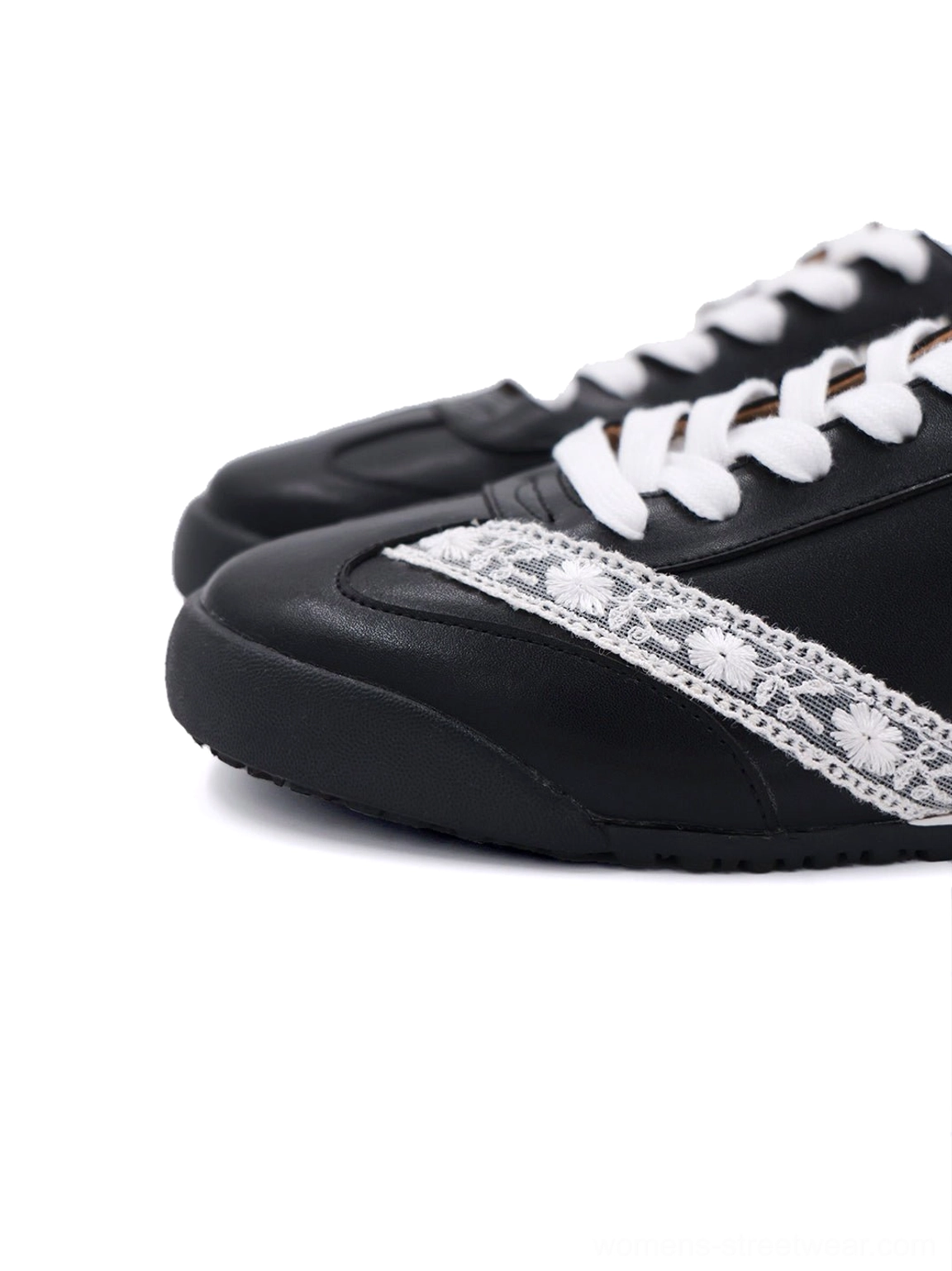 Close-up of black and white microfiber leather low-profile sneaker with floral lace side applique and white laces