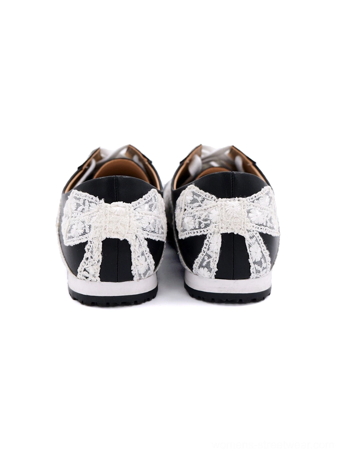 Rear view of black and white floral lace low-profile sneakers displaying matching bow decorations at both heels