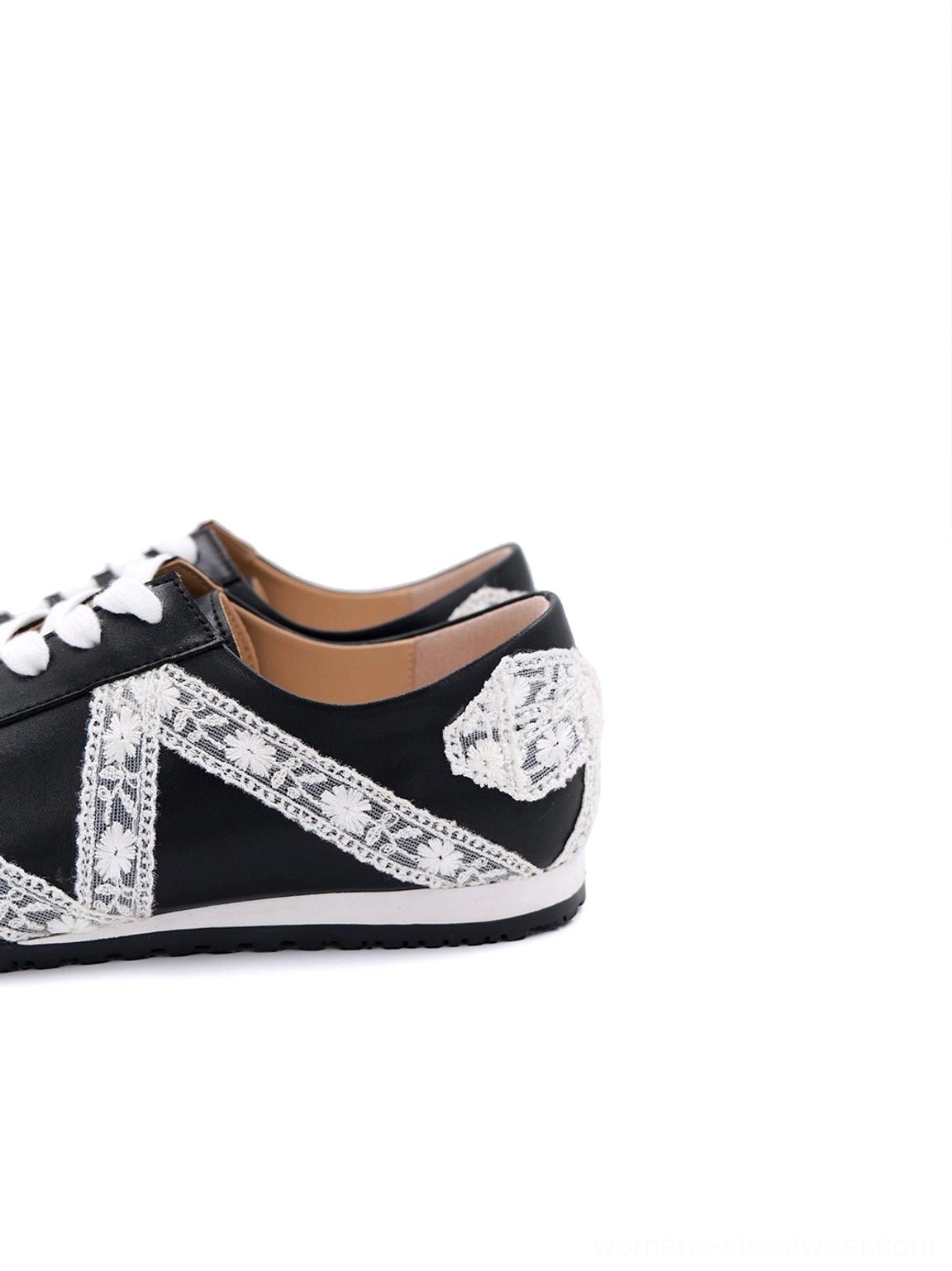 Three-quarter side view of black and white floral lace microfiber leather low-profile sneakers with gum sole and heel bow
