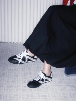 Black and white floral lace low-profile sneakers worn with a long black skirt in a Korean streetwear outfit