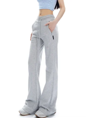 Flower Ash high-waist flared streetwear sweatpants shown from a three-quarter side angle with exposed drawstring and relaxed flared fit